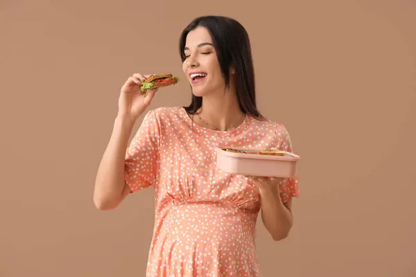 Junge Schwangere Frau Mit Leckerem Sandwich Und Lunchbox Auf Farbigem — Stockfoto