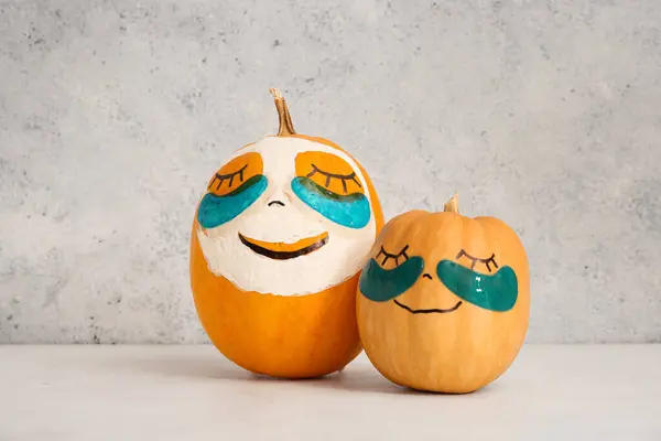 Pumpkins with under-eye patches and mask on light table