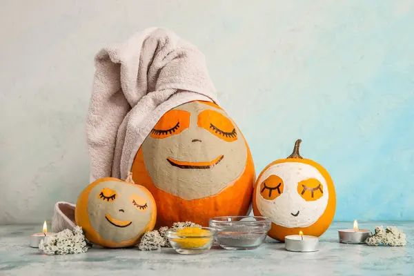 Pumpkins with masks and spa supplies on grunge table