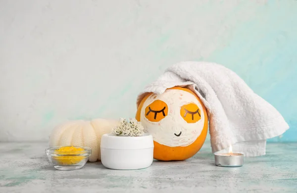 Pumpkin with mask and spa supplies on grunge table