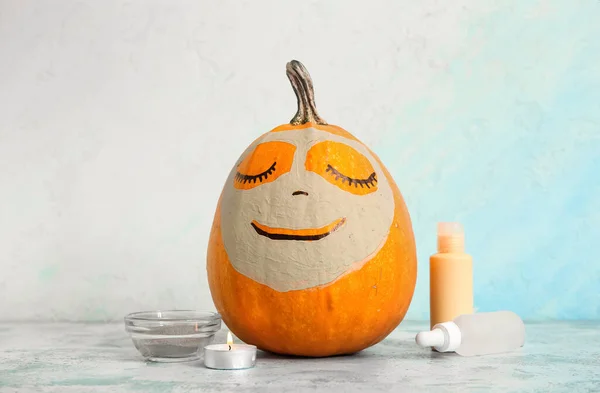Pumpkin with clay mask and spa supplies on grunge table