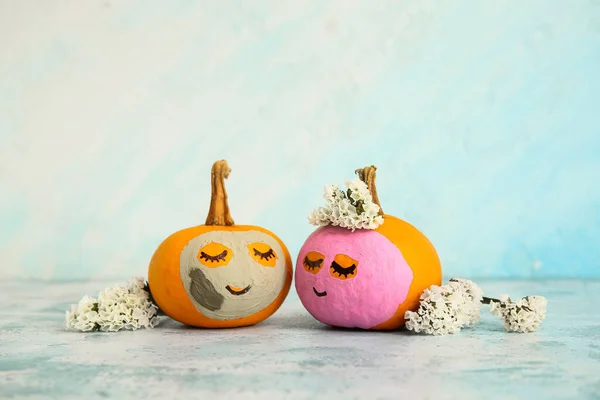 Pumpkins with masks and flowers on grunge table