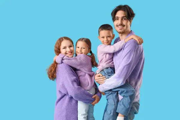 Happy family in warm sweaters on blue background