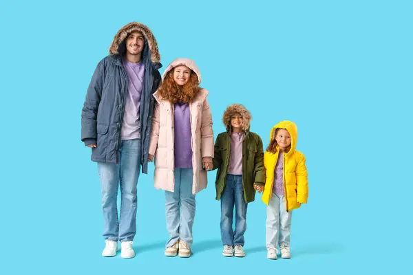 Happy family in puffer jackets on blue background