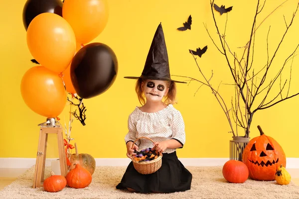 Dziewczynka Ubrana Halloween Jako Czarownica Cukierkami Balonami Pobliżu Żółtej Ściany — Zdjęcie stockowe