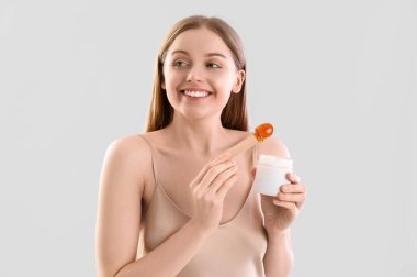 Hafif arka planda şekerleme macunu olan güzel bir genç kadın.