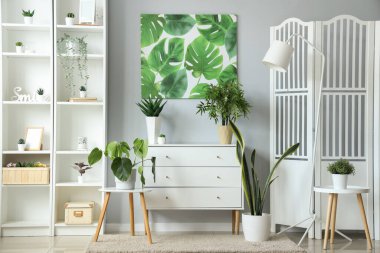 Açık oturma odasının iç tarafında yeşil çiçekli çekmeceler.