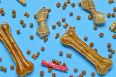 Mavi arka planda farklı köpek muamelesi içeren kompozisyon