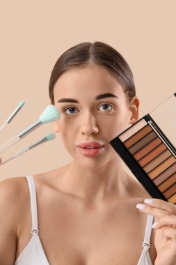 Dekoratif makyaj malzemeleri ve hafif arka planda makyaj fırçaları olan genç bir kadın.