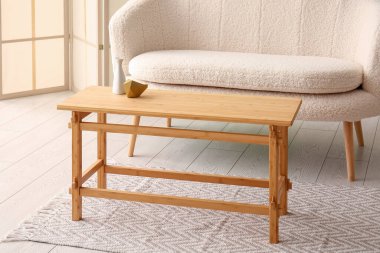 Oturma odasının içinde vazo ve dekor olan ahşap bir sehpa.