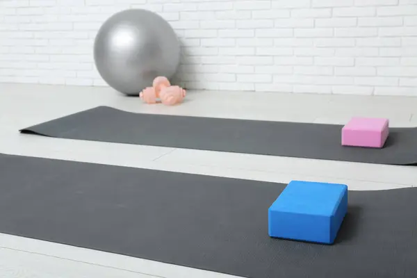 Yoga mats with foam exercise blocks in interior of gym
