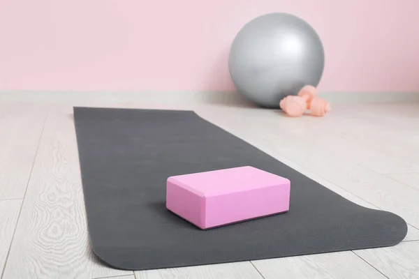 Yoga mats with foam exercise block in interior of gym