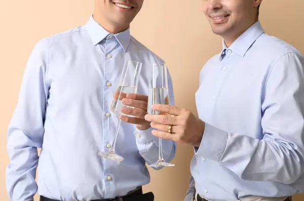 Verheiratetes Homosexuelles Paar Mit Champagnergläsern Auf Beigem Hintergrund Nahaufnahme — Stockfoto