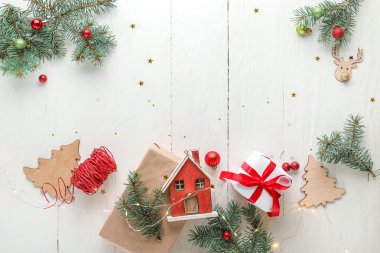 Noel ışıkları, hediye kutusu, oyuncak evi ve beyaz ahşap arka planda dekor.