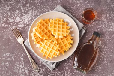 Gri arkaplanda akçaağaç şurubuyla lezzetli waffle tabağı