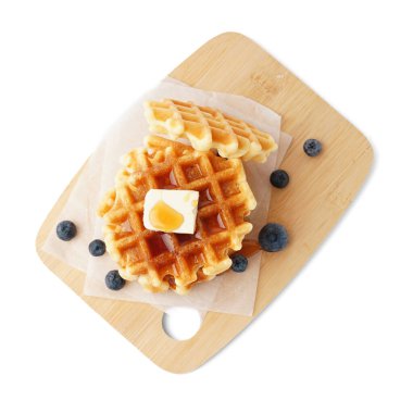 Beyaz arka planda böğürtlen ve akçaağaç şurubuyla lezzetli waffle tahtaları.