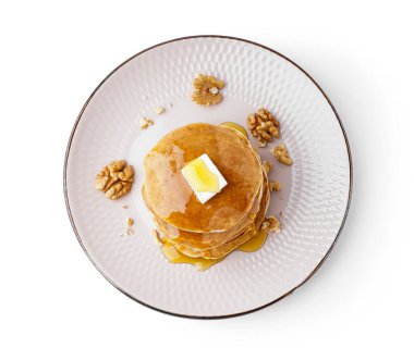 Beyaz arka planda tereyağlı, fındıklı ve akçaağaç şuruplu lezzetli krepler.