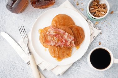 Pastırmalı gözleme, akçaağaç şurubu, fındık ve beyaz arka planda bir fincan kahve.