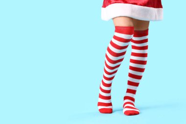 Mavi arka planda Noel çoraplı genç bir kadın.