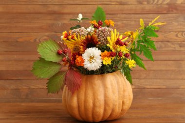 Ahşap zemin üzerinde balkabağı yaprakları ile güzel sonbahar buketi