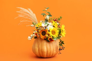 Turuncu arka planda balkabağında güzel bir sonbahar buketi