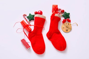 Güzel dekorasyonlu Noel çorapları ve beyaz arka planda hediye kutuları.