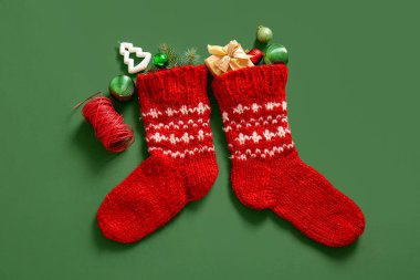 Güzel süslemeli Noel çorabı ve yeşil arka planda hediye kutusu.
