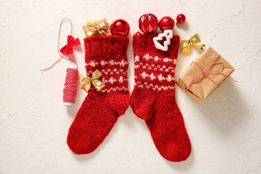 Topları, yayları ve beyaz arka planda hediye kutuları olan Noel çorapları.