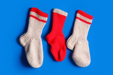 Mavi arka planda asılı farklı Noel çorapları