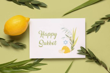 Dört tür (lulav, hadas, arava, etrog) ve yeşil arka planda Mutlu SUKKKOT yazılı tebrik kartı