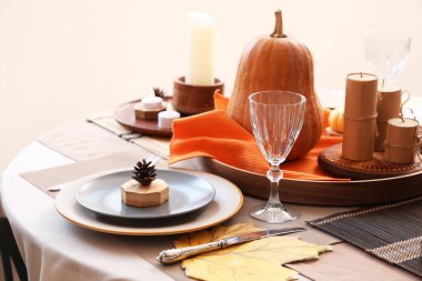 Şükran Günü yemeği için balkabaklarıyla, kozalaklarla ve mumlarla dolu güzel bir masa.