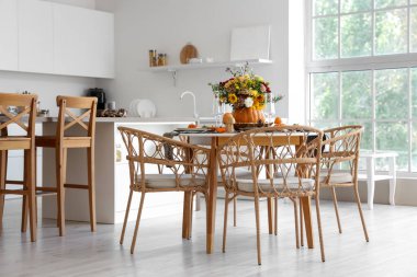 Mutfaktaki yemek masasında sonbahar çiçekli balkabağı.