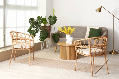 Parlak oturma odasının içinde koltuklar, kanepe ve sehpa var.