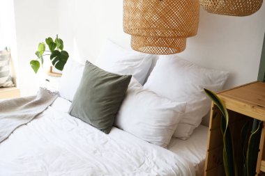 Yatak odasında yastıkları olan rahat bir yatak.