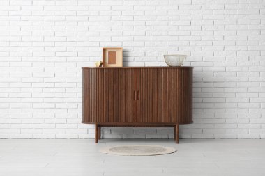 Çekmecenin modern sandığı ve dekorasyon odasındaki hafif tuğla duvarın yanında.