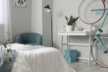 Rahat yatağı, koltuğu ve bisikleti olan hafif çocukların yatak odasının içi.