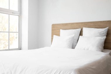 Konforlu çift kişilik yatak odası ve beyaz yastıklar.