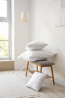 Yastıklı gri bank ve beyaz duvarın yanında standart lamba