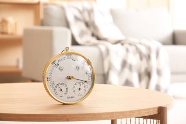 Odadaki masada aneroid barometre, yakın plan.