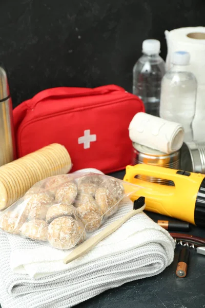 Necessities for emergency bag on dark table, closeup