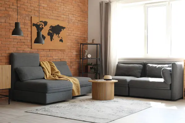 Interior of stylish living room with cozy sofa, armchairs and coffee table