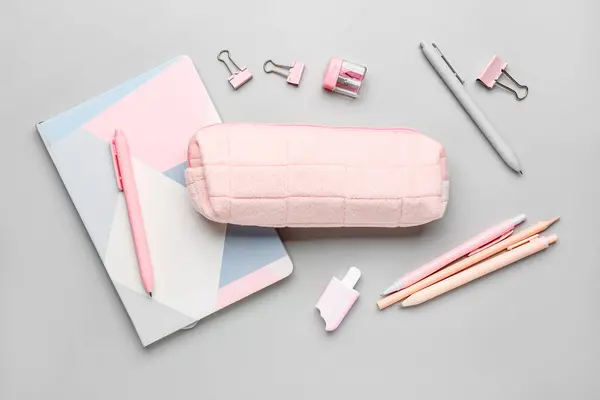 Pencil case with school stationery on grey background