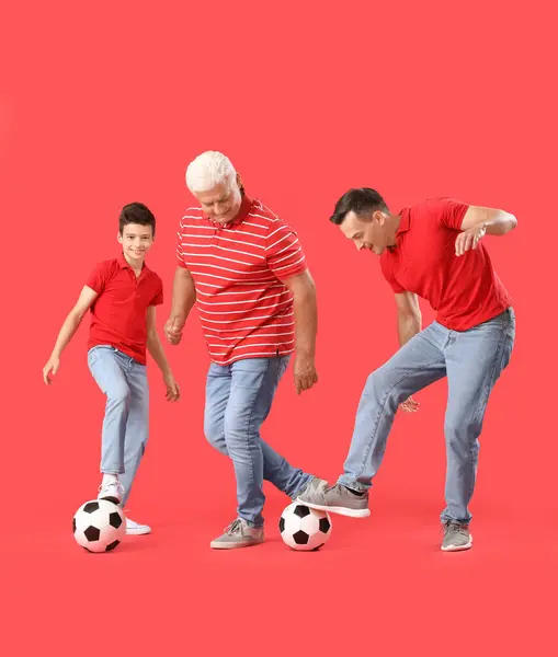 小男孩 他的父亲和祖父在红色背景下踢足球 — 图库照片