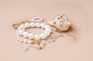 Pembe arka planda deniz kabuğu olan farklı güzel bilezikler.