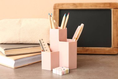 Masasında farklı kırtasiye malzemesi olan tahta ve tutucu, yakın plan.