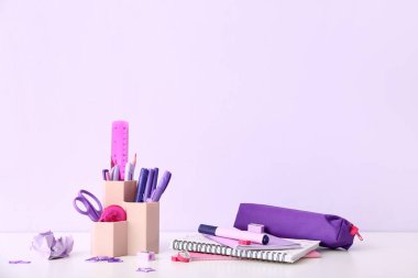 Işık masasında farklı kırtasiye malzemesi ve defterleri olan tutucu