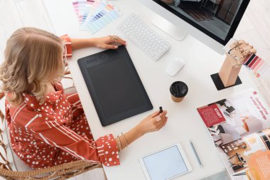 Ofisteki masadaki grafik tabletle çalışan kadın iç mimar, üst görünüm