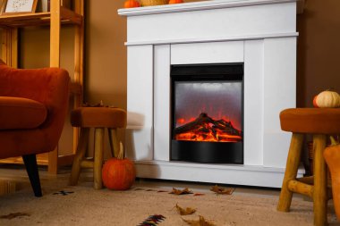 Balkabakları, şöminesi ve tabureleri olan bir oturma odası.