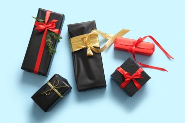 Hediye kutuları ve mavi arka planda Noel ağacı dalı