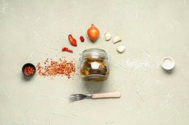 Lezzetli salatalıklı kavanoz ve yeşil arka planda farklı baharatlar.